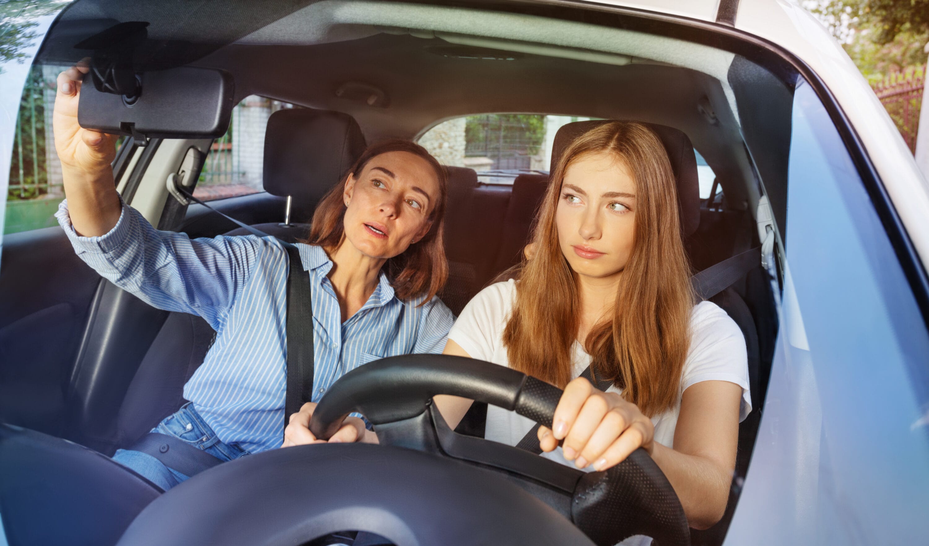 Teenage girl and her mother during driving lesson in a car