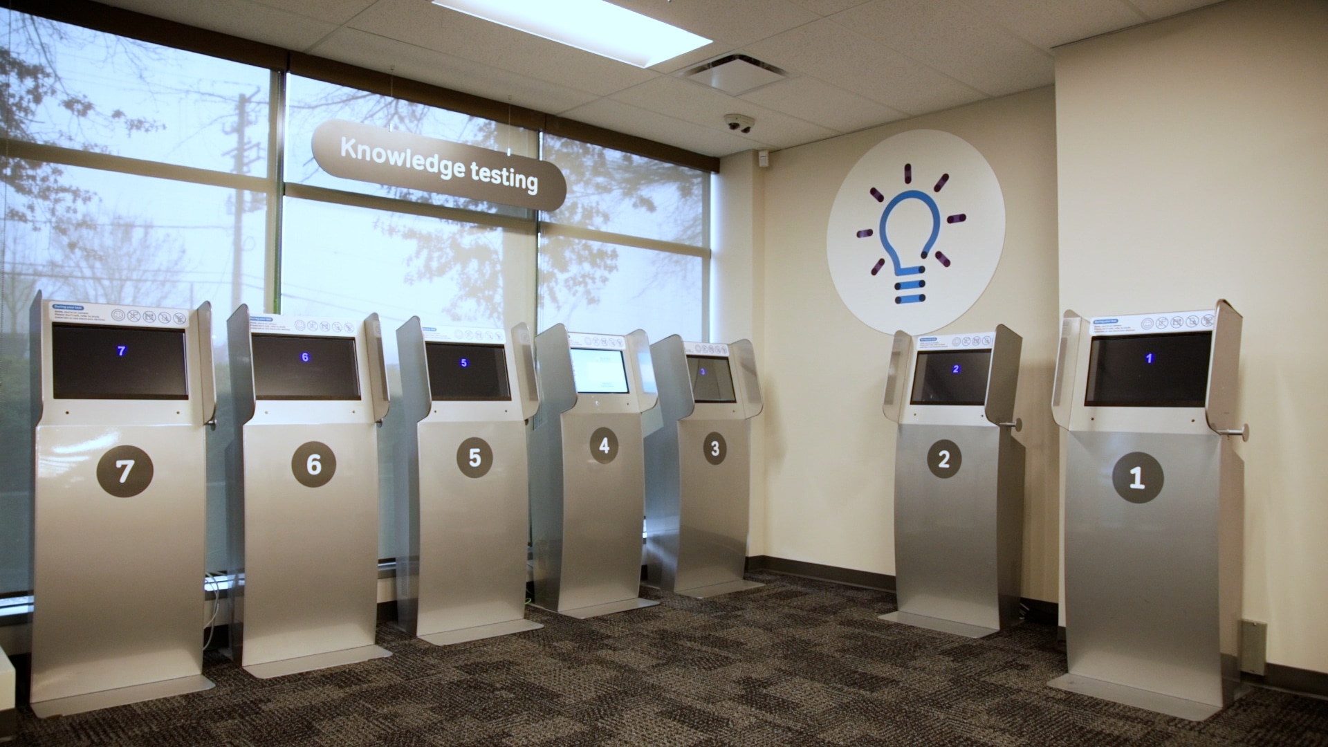 A row of ICBC computer kiosks in a knowledge testing room, used for taking the driver's license written exam in British Columbia.