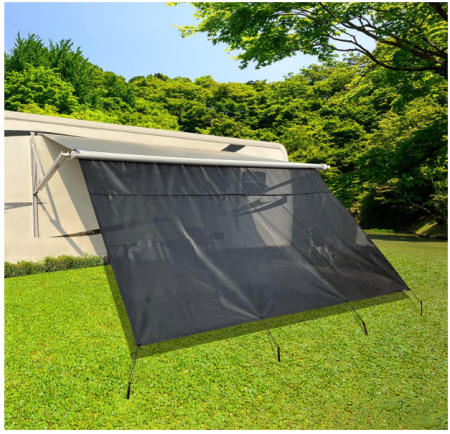 An RV with a white awning and a black mesh shade screen attached to the side, providing a shaded outdoor area.