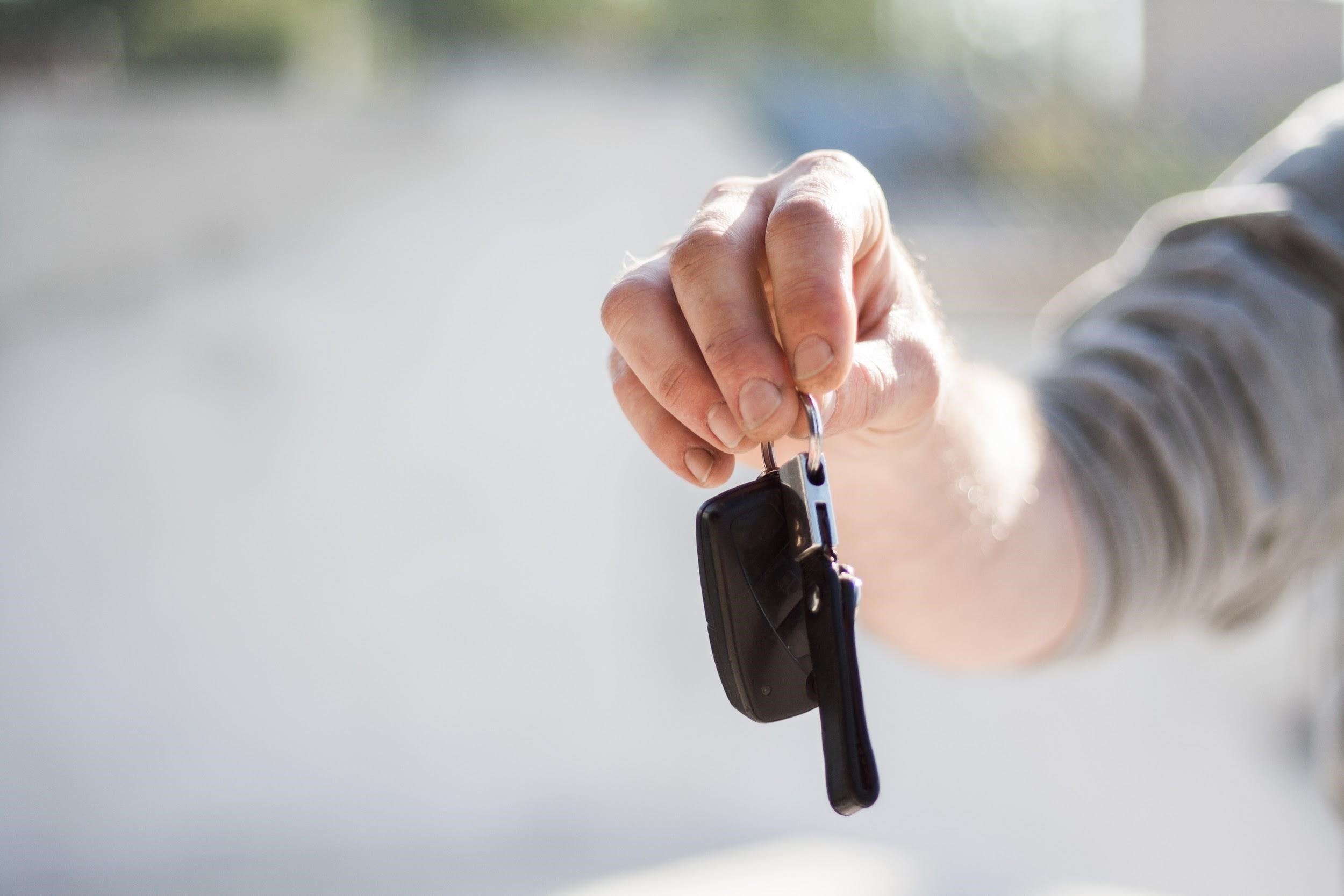 a hand holding a set of car keys.