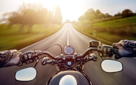 POV shot of young man riding on a motorcycle. Hands of motorcyclist on a stree