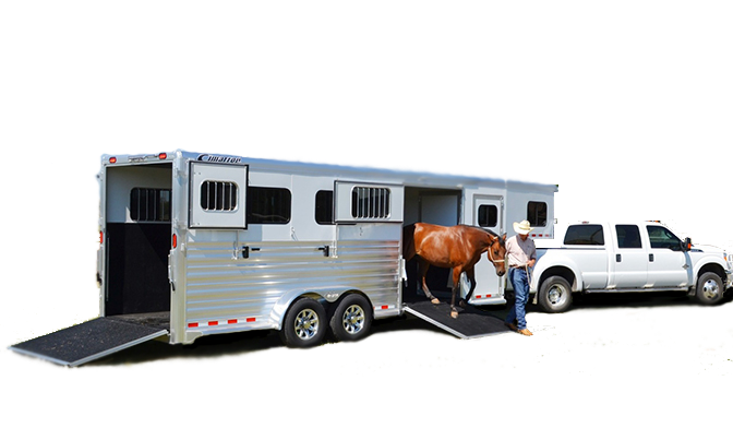 A man leading a brown horse down a side ramp of a large silver gooseneck horse trailer attached to a white pickup truck.