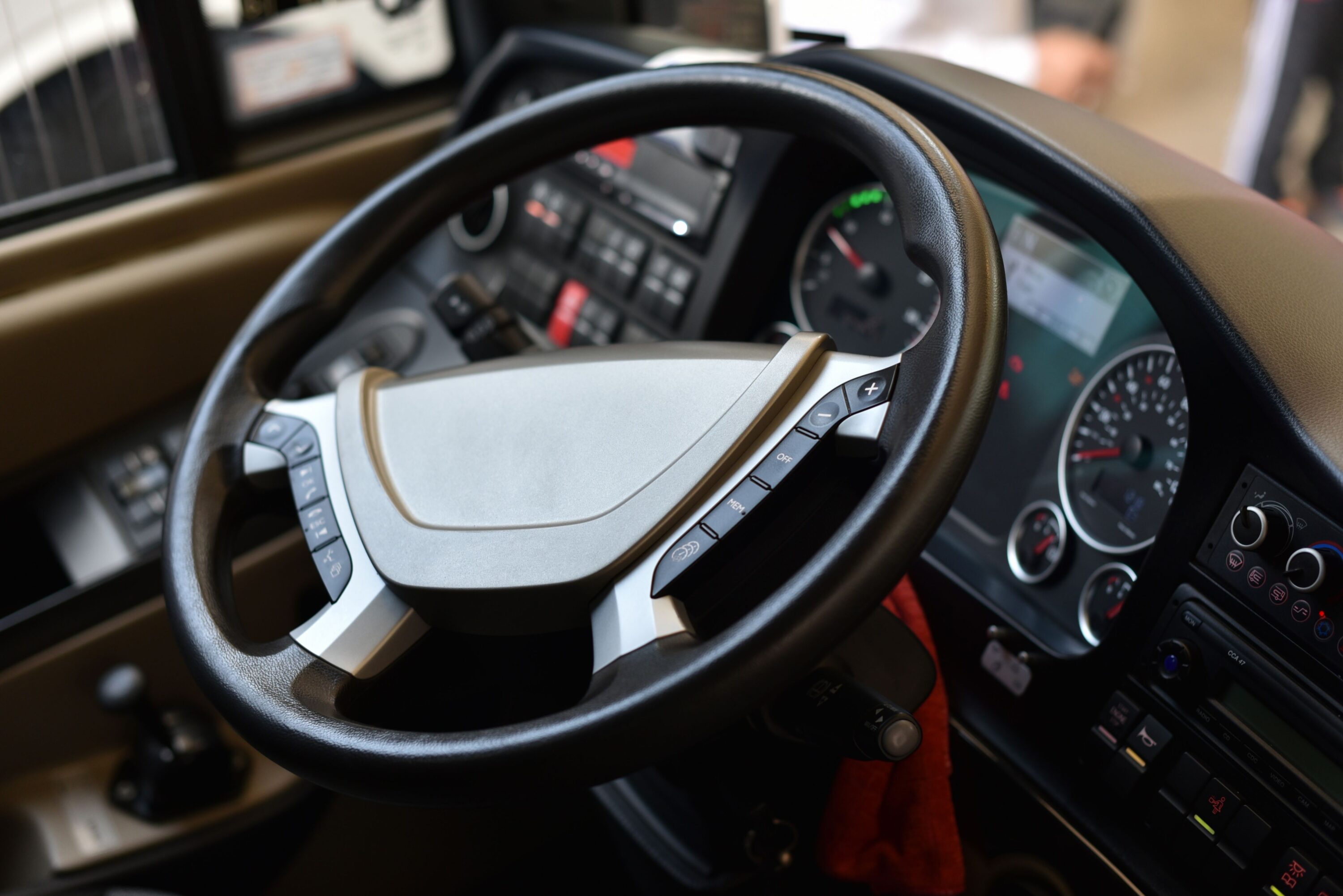 Driver's view of a bus cockpit and gear shifter, with instrument dials slightly out of focus