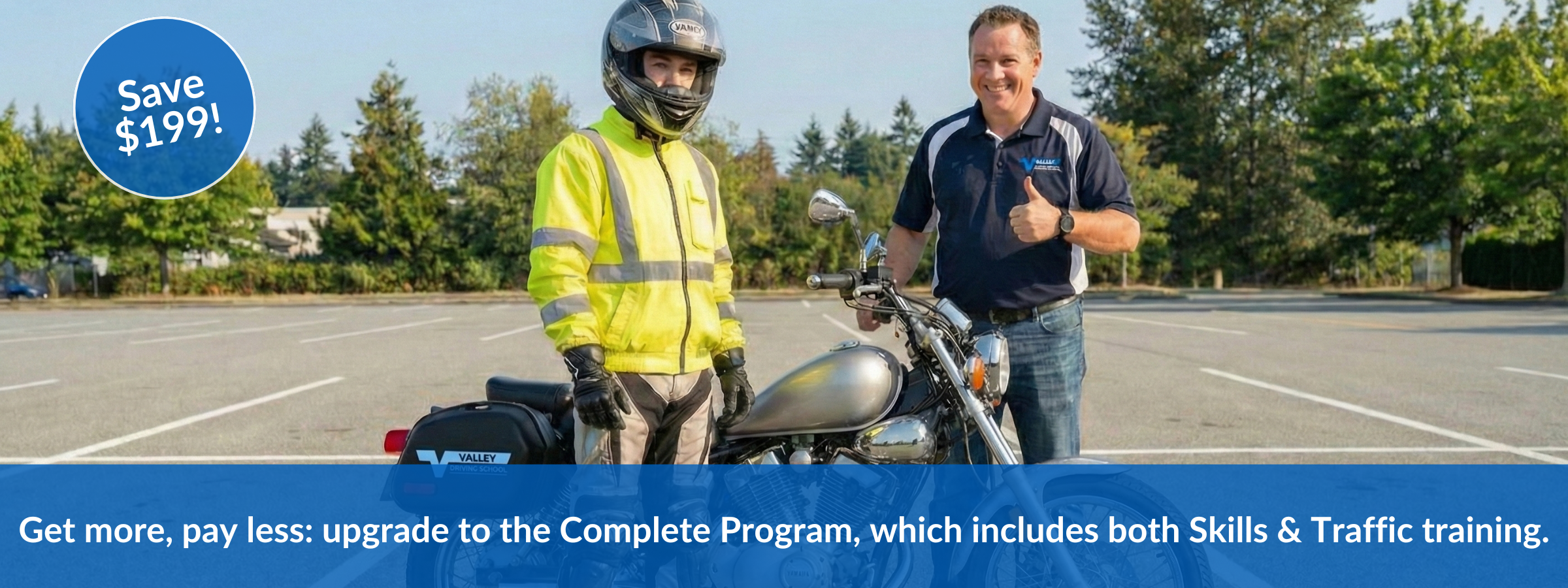 Valley Driving School motorcycle student in high-visibility jacket standing beside a Valley instructor giving a thumbs up, with a motorcycle in a training parking lot in Abbotsford, BC.
