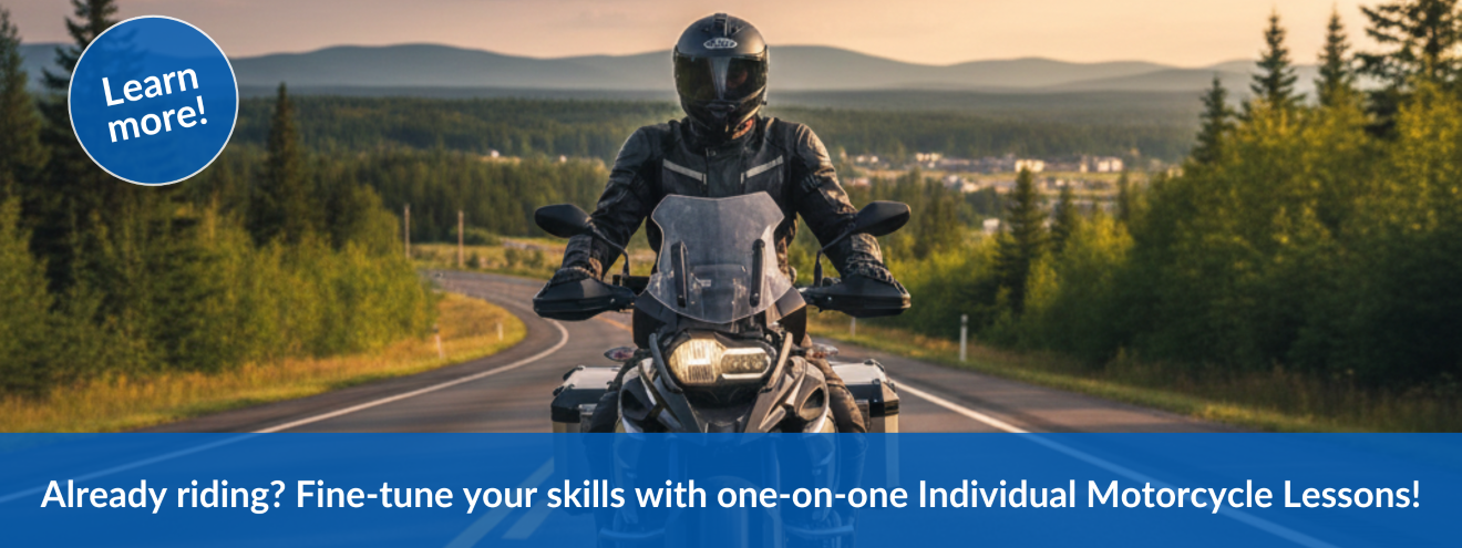 A motorcycle rider in full gear, black helmet riding a black motorcycle down a two lane road. The graphic says: "Already riding? Fine-tune your skills with one-on-one individual lessons!" Click to learn more!