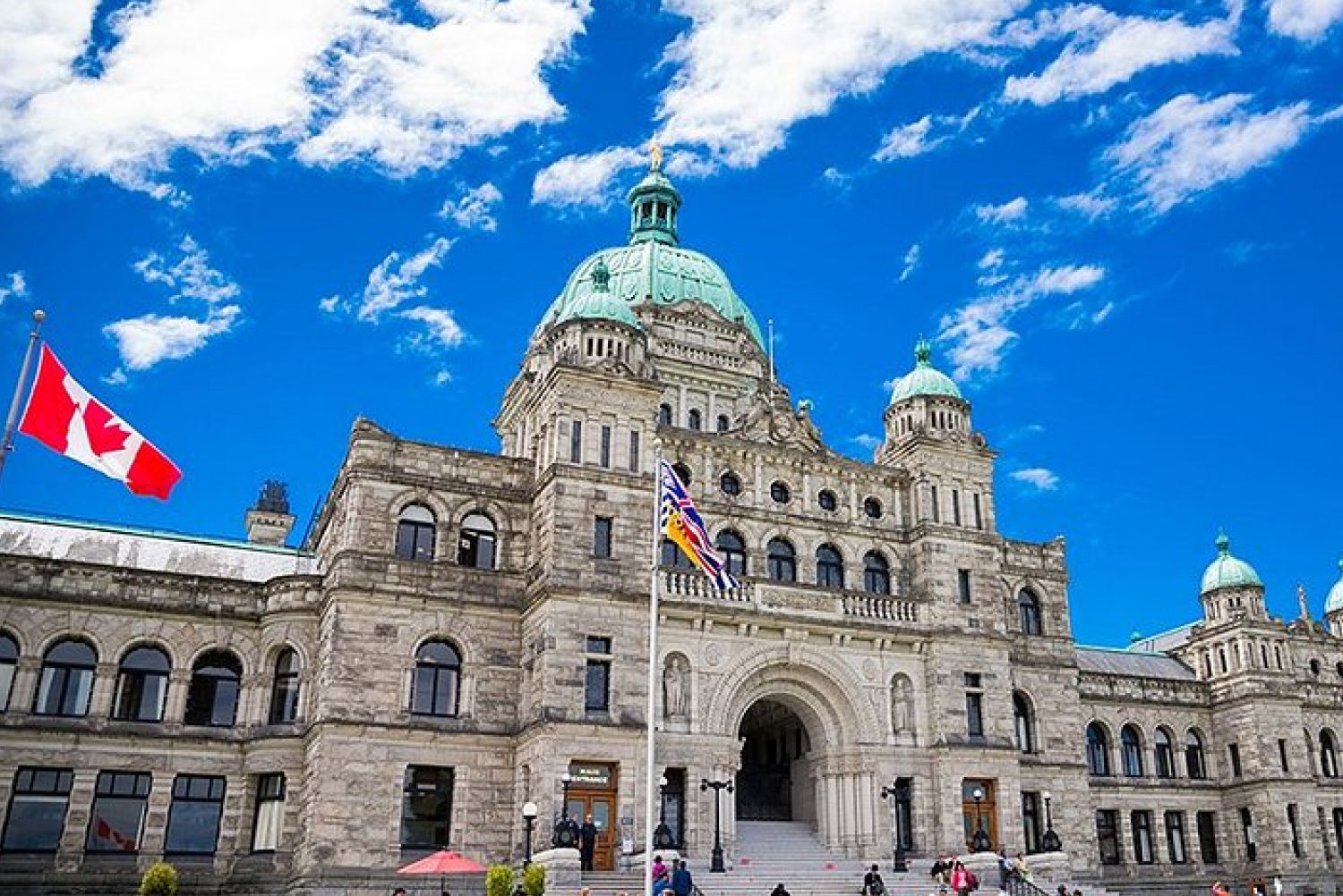 The British Columbia Parliament Buildings in Victoria under a clear blue sky.